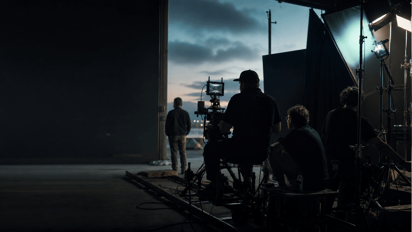 A professional film crew operating a cinema camera on set at blue hour